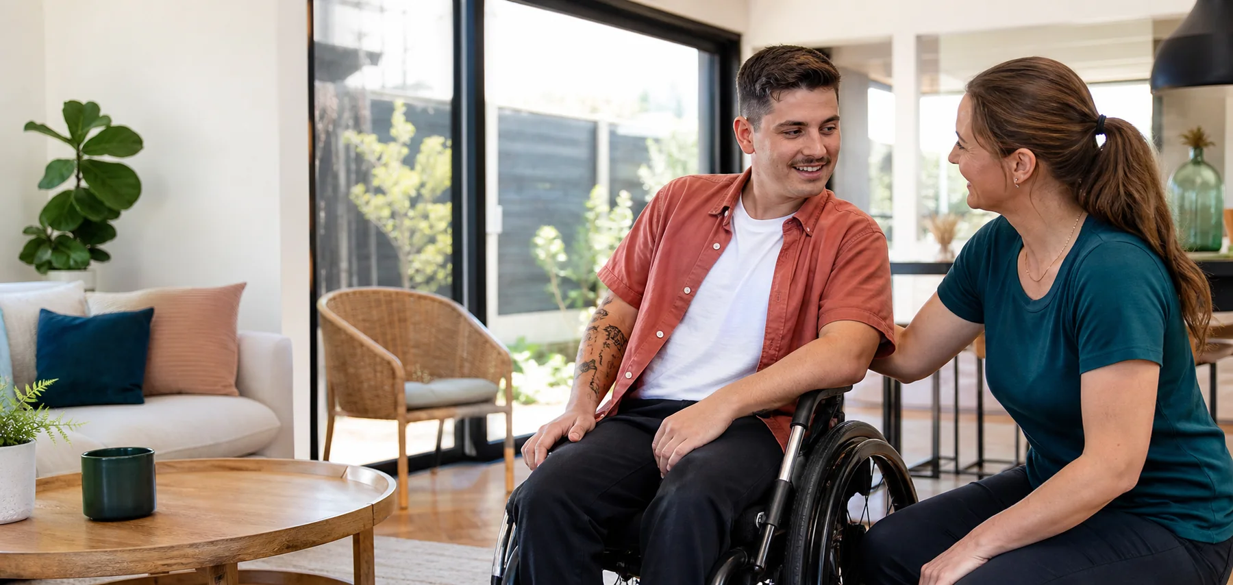 A disability support worker listening to an adult participant at home